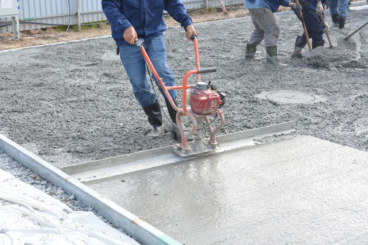 Concreter power-screeding a freshly poured concrete slab